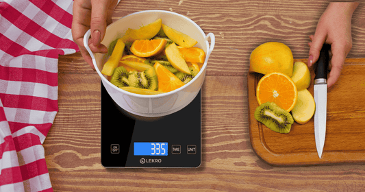 Persoon die een digitale keukenweegschaal gebruikt om citrusvruchten te wegen.